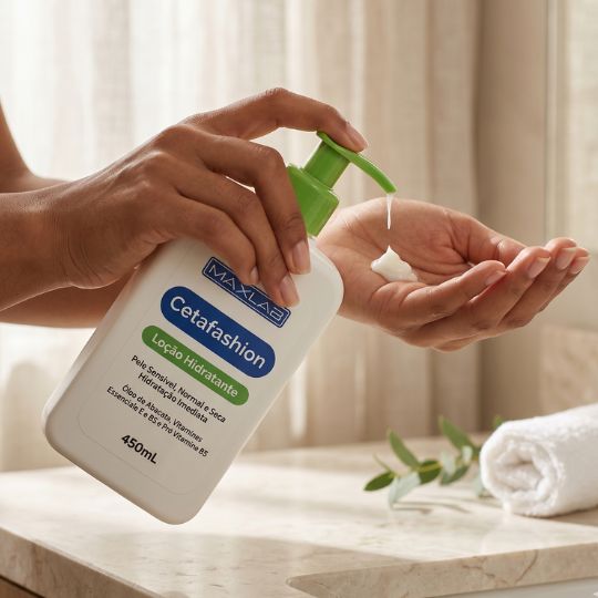 Loção Hidratante Cetafashion MaxLab sendo aplicada nas mãos por uma mulher em ambiente clean e sofisticado
