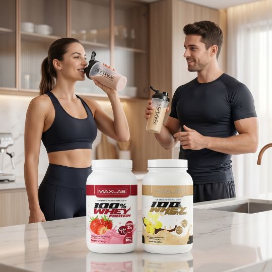 Casal jovem em trajes de treino bebendo 100% Whey Protein Maxlab sabores morango e baunilha em uma cozinha moderna